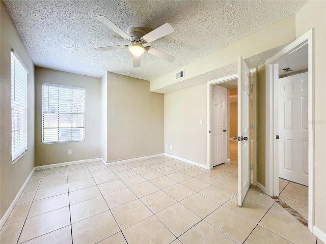 tiled spare room featuring ceiling fan and a textured ceiling