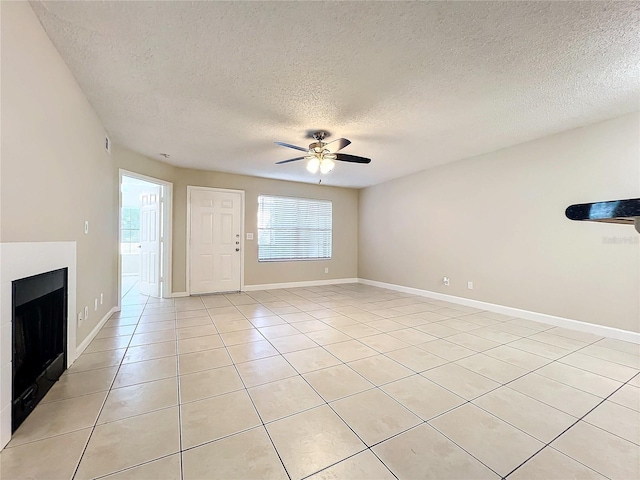 unfurnished living room with a ceiling fan, light tile patterned flooring, a fireplace, and baseboards