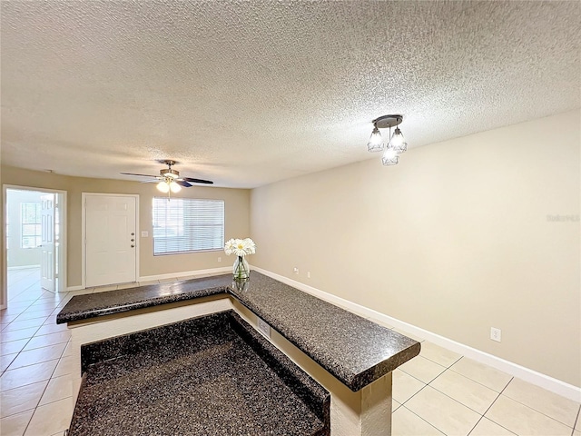 interior space featuring a healthy amount of sunlight, baseboards, and light tile patterned flooring