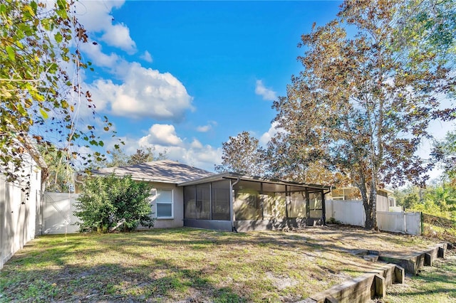 back of property featuring a sunroom and a yard