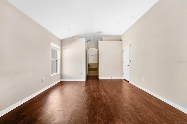 unfurnished room featuring dark wood-type flooring and vaulted ceiling