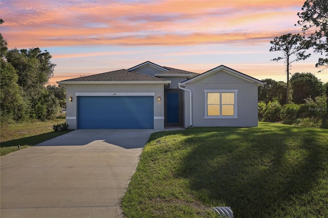 ranch-style house with a yard and a garage