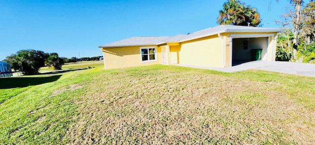 rear view of house with a yard and a garage