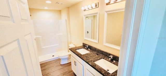 bathroom featuring vanity, toilet, wood-type flooring, and walk in shower