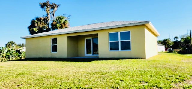 rear view of property featuring a lawn