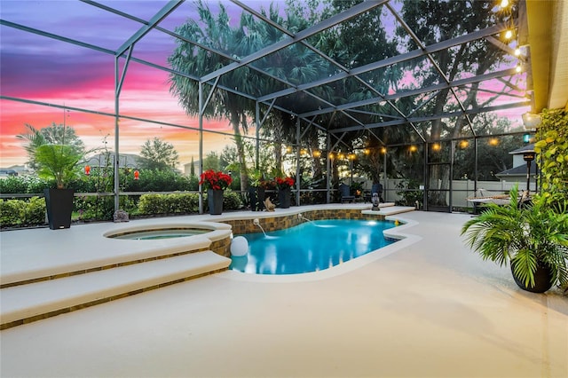 pool at dusk featuring a patio area, an in ground hot tub, and glass enclosure