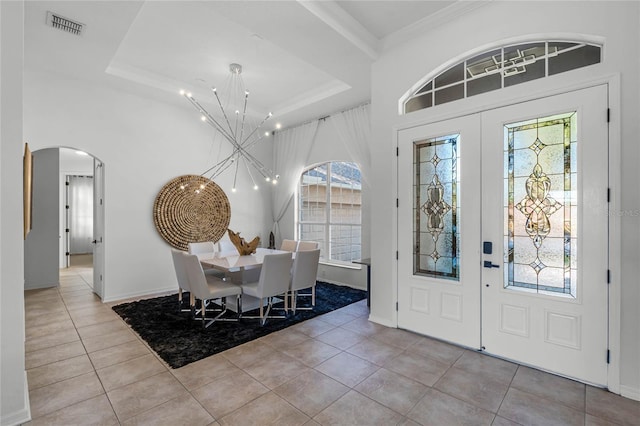 foyer featuring french doors, light tile patterned flooring, and a tray ceiling