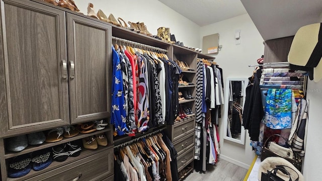 walk in closet with light wood-type flooring