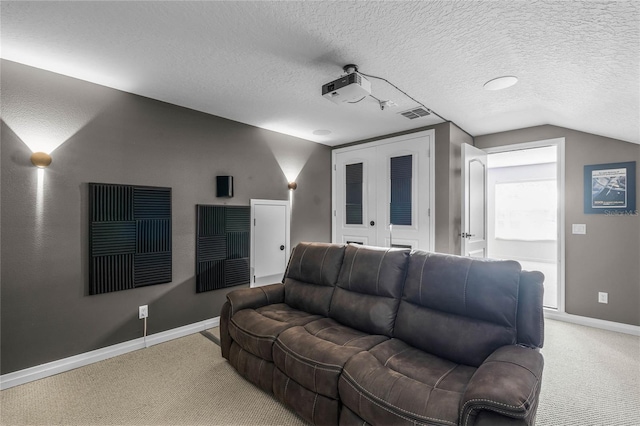 home theater with a textured ceiling, vaulted ceiling, and carpet flooring