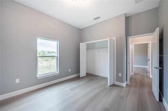 unfurnished bedroom featuring a closet and light wood-type flooring