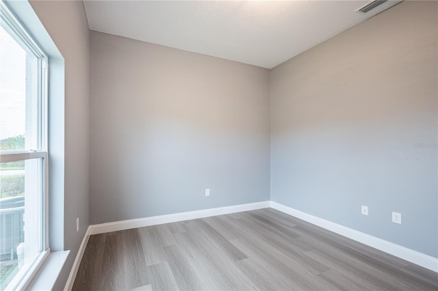 unfurnished room featuring light hardwood / wood-style floors and a textured ceiling