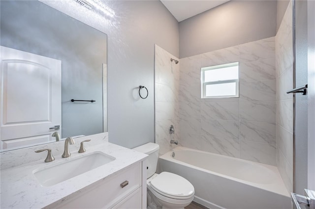 full bathroom with vanity, tiled shower / bath combo, and toilet