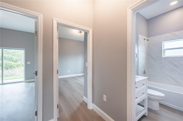 full bathroom featuring vanity, hardwood / wood-style flooring, toilet, and tiled shower / bath