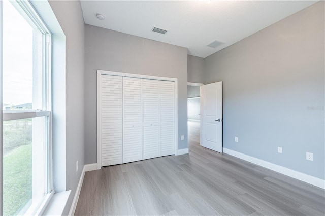 unfurnished bedroom with a closet and light wood-type flooring