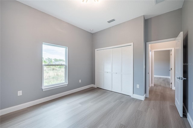 unfurnished bedroom featuring light wood-type flooring and a closet