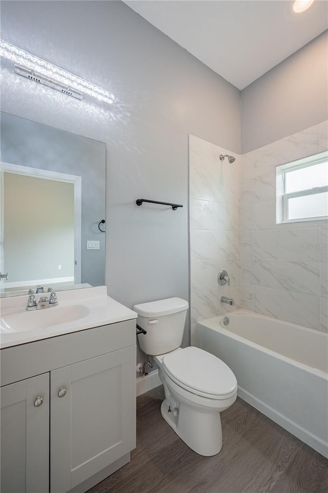 full bathroom featuring toilet, vanity, tiled shower / bath combo, and hardwood / wood-style flooring