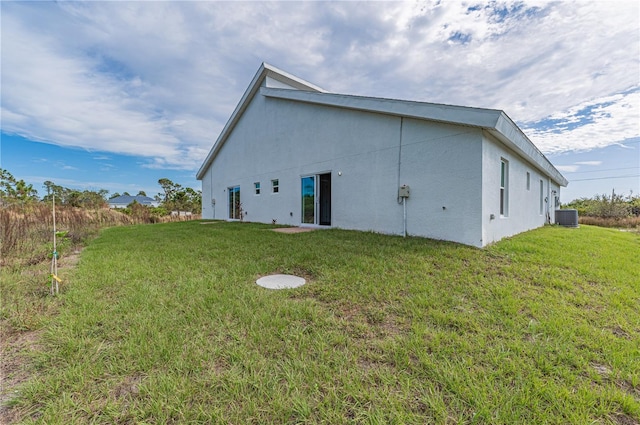 rear view of house with a yard and central AC unit