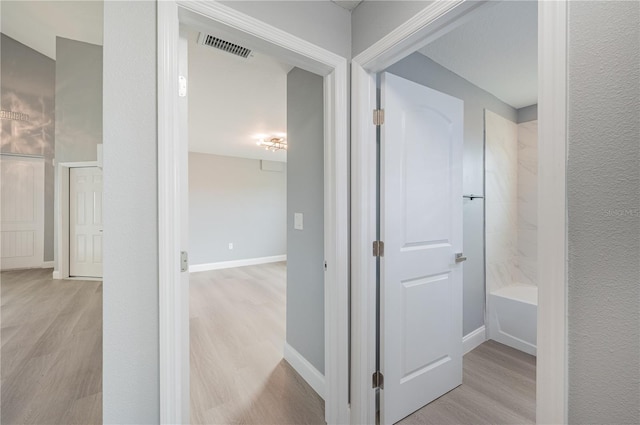 corridor with light hardwood / wood-style flooring