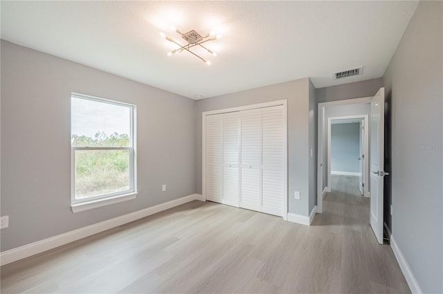 unfurnished bedroom featuring light wood-type flooring and a closet