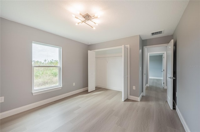 unfurnished bedroom featuring a closet and light wood-type flooring