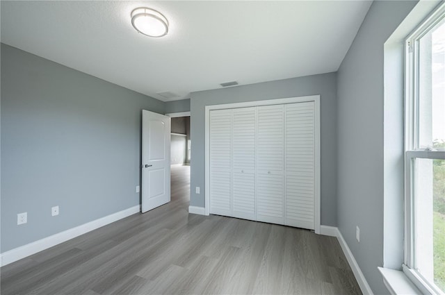 unfurnished bedroom featuring a closet and light hardwood / wood-style flooring