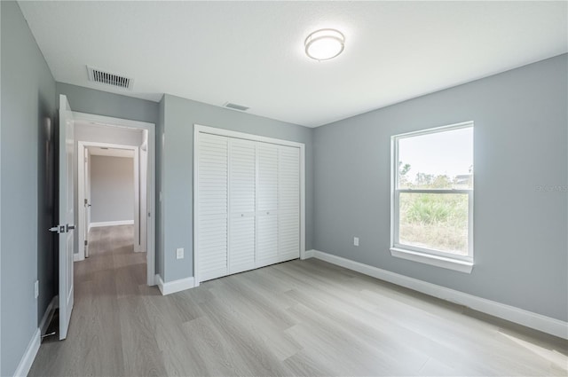 unfurnished bedroom featuring a closet and light hardwood / wood-style floors