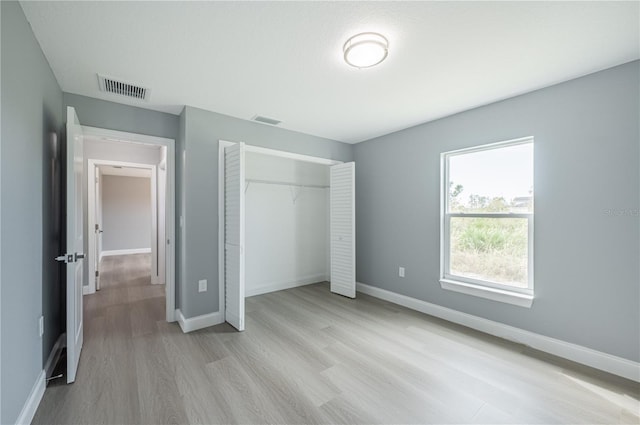 unfurnished bedroom with a closet and light wood-type flooring