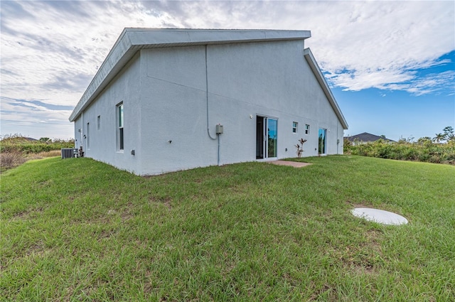 back of property featuring a lawn and central AC unit