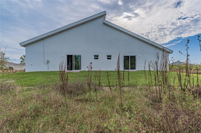 back of house with a lawn