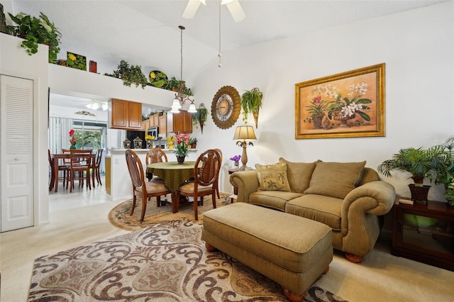 living room with ceiling fan, lofted ceiling, and light carpet