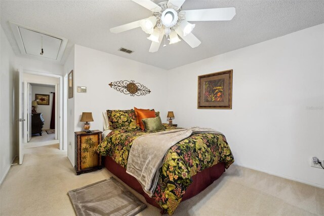 carpeted bedroom featuring ceiling fan and a textured ceiling