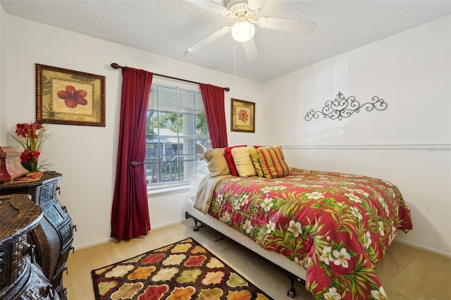 bedroom featuring ceiling fan, light colored carpet, and a textured ceiling