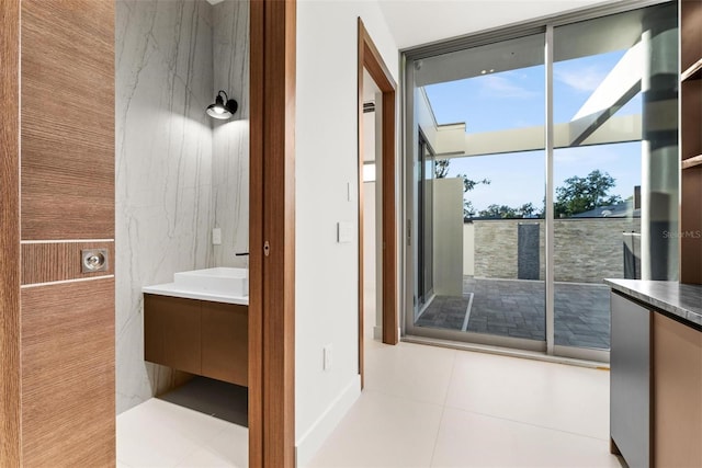 bathroom with a wealth of natural light, tile patterned flooring, and vanity