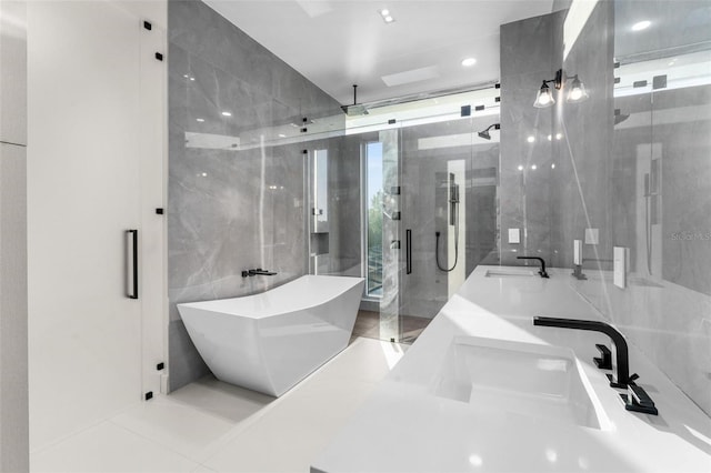 bathroom featuring separate shower and tub, tile patterned floors, vanity, and tile walls