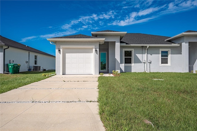 view of front of home with central air condition unit, a front lawn, and a garage