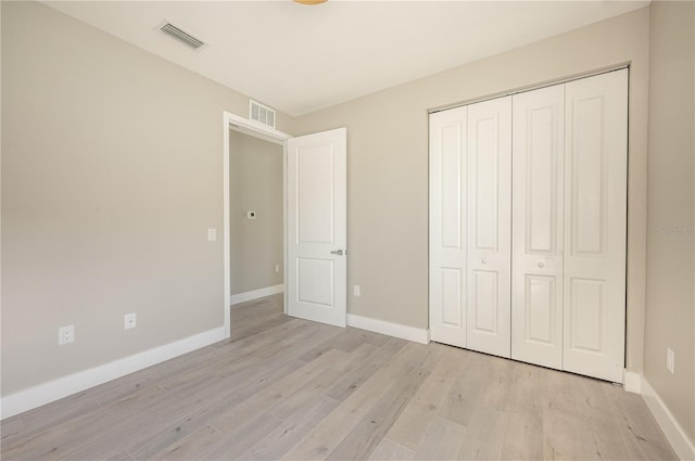 unfurnished bedroom featuring a closet and light wood-type flooring