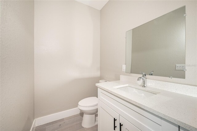 bathroom with vanity, toilet, and wood-type flooring