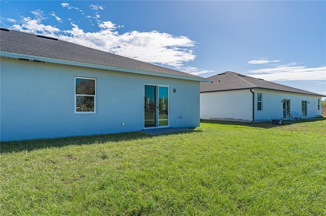 back of house featuring a lawn