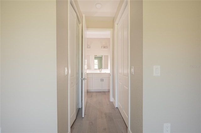 hallway featuring light hardwood / wood-style flooring and sink