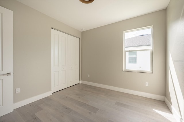 unfurnished bedroom featuring a closet and light wood-type flooring