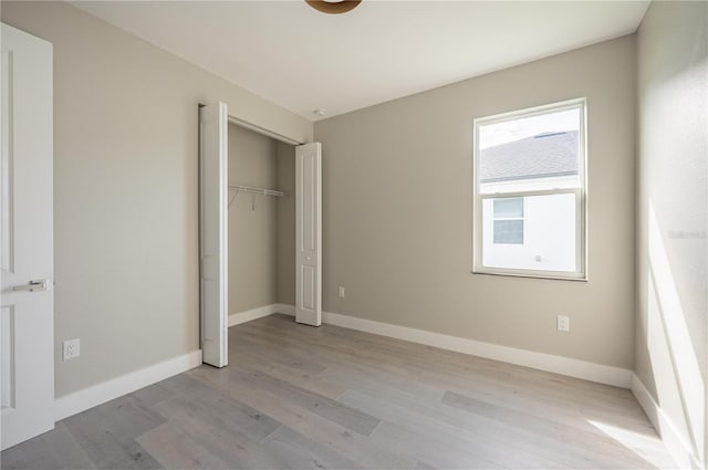 unfurnished bedroom with light hardwood / wood-style floors and a closet