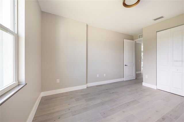 unfurnished bedroom featuring light hardwood / wood-style floors and a closet