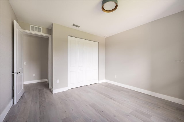 unfurnished bedroom with a closet and light hardwood / wood-style flooring