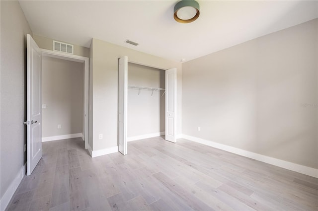 unfurnished bedroom with light hardwood / wood-style floors and a closet