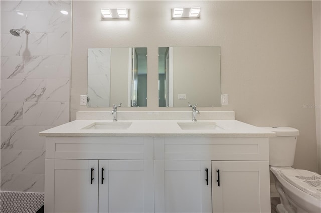 bathroom featuring a tile shower, vanity, and toilet