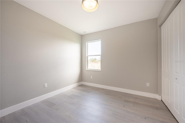 unfurnished bedroom with a closet and light hardwood / wood-style flooring