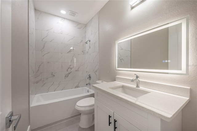 full bathroom with vanity, tiled shower / bath combo, and toilet