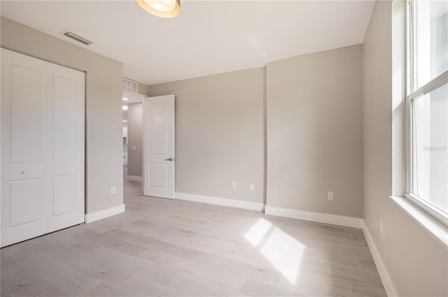 unfurnished bedroom featuring light wood-type flooring and a closet