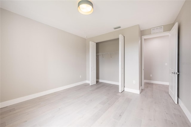 unfurnished bedroom with a closet and light wood-type flooring