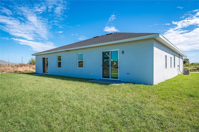 rear view of property with a lawn and central air condition unit